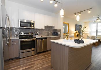 A modern kitchen with a large island and stainless steel appliances.